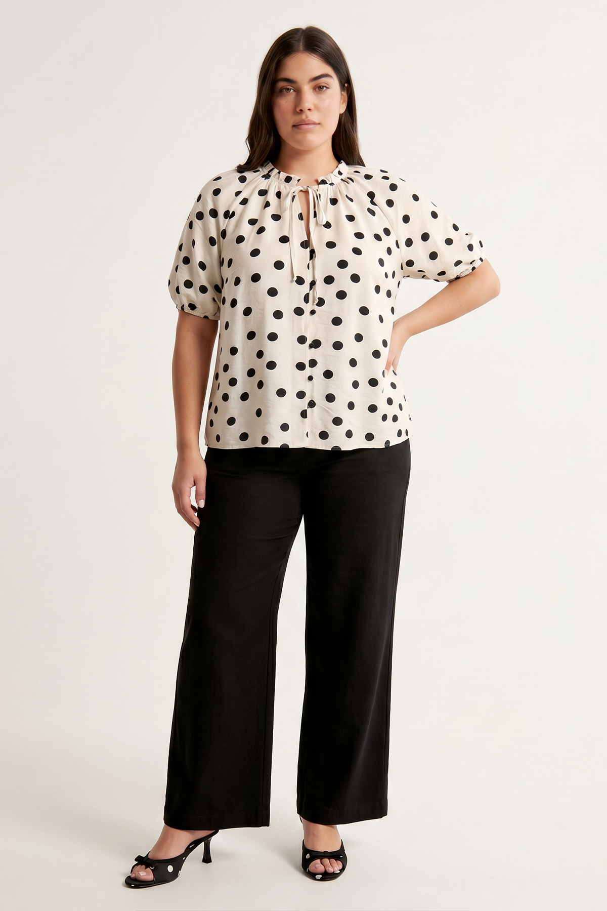 Model wearing a polka dot büyük beden bluz and black wide-leg pants.